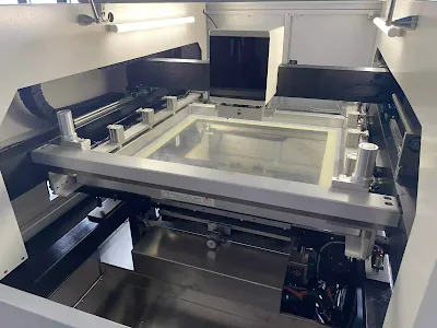 Frame stencil in an automated printer for high-volume SMT solder paste process.