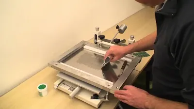Hobbyist aligning a stencil over a PCB for solder paste application