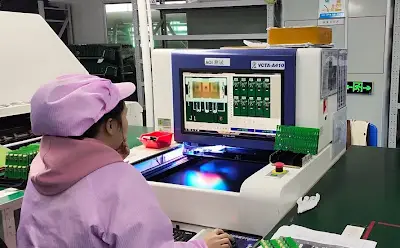 Engineer reviewing fault data from In-Circuit testing machine on production line monitor