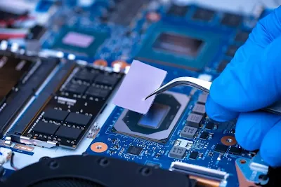 Engineer installing a thermal pad on a power supply component
