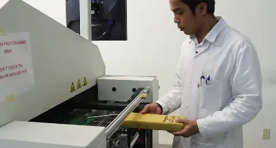 Technician inspecting conveyor belt and heaters in SMT reflow oven