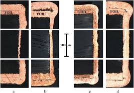 micrograph showing base foil, electroless copper, and electroplated copper layers in a plated-through hole