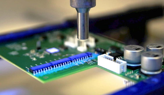 Robotic arm applying conformal coating to specific PCB areas