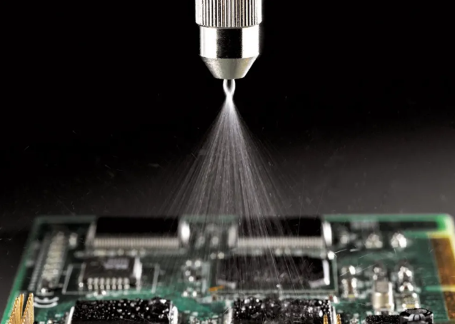 Automated spray nozzle applying conformal coating to a PCB