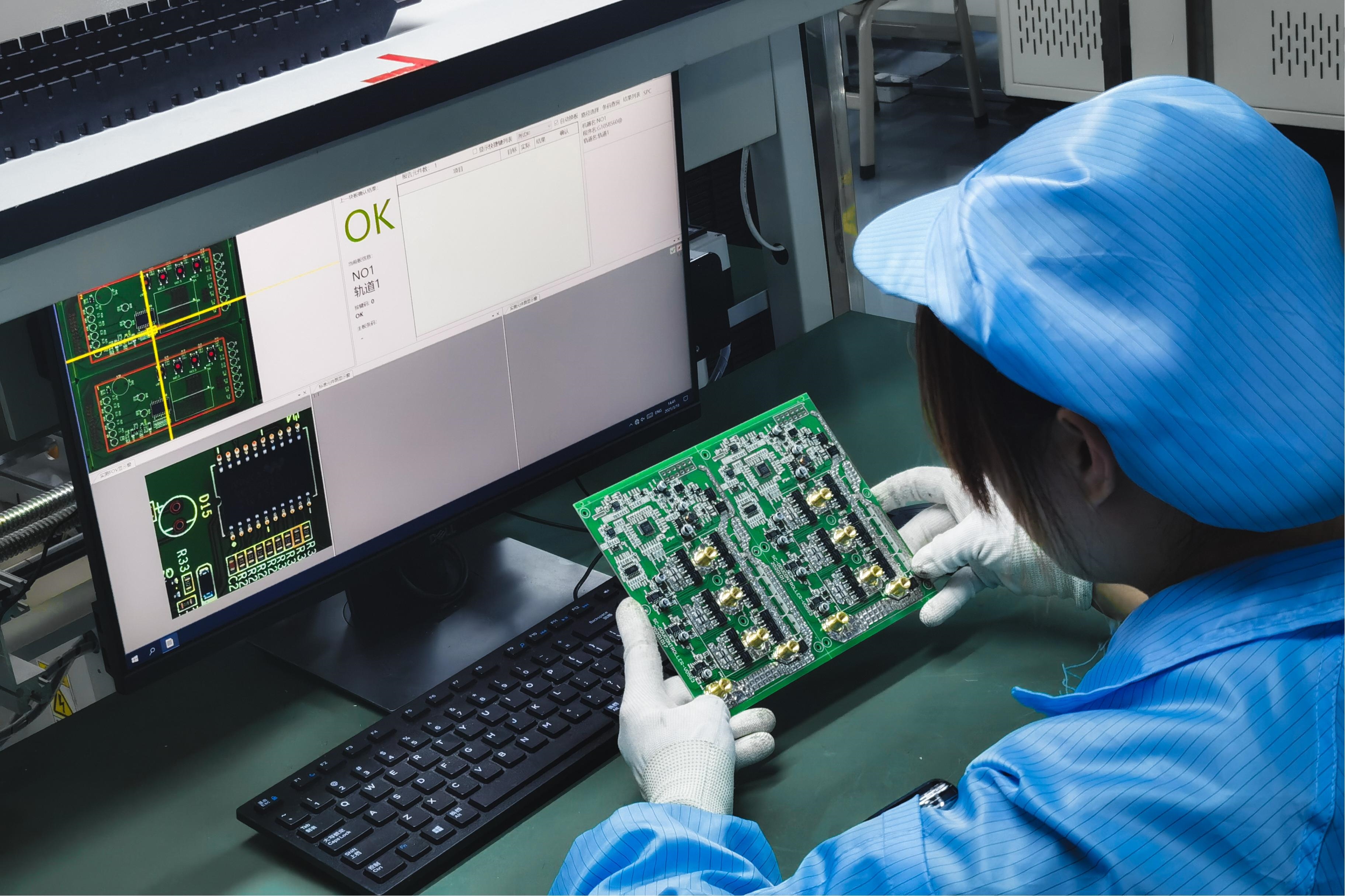 Technician inspecting a PCB during assembly