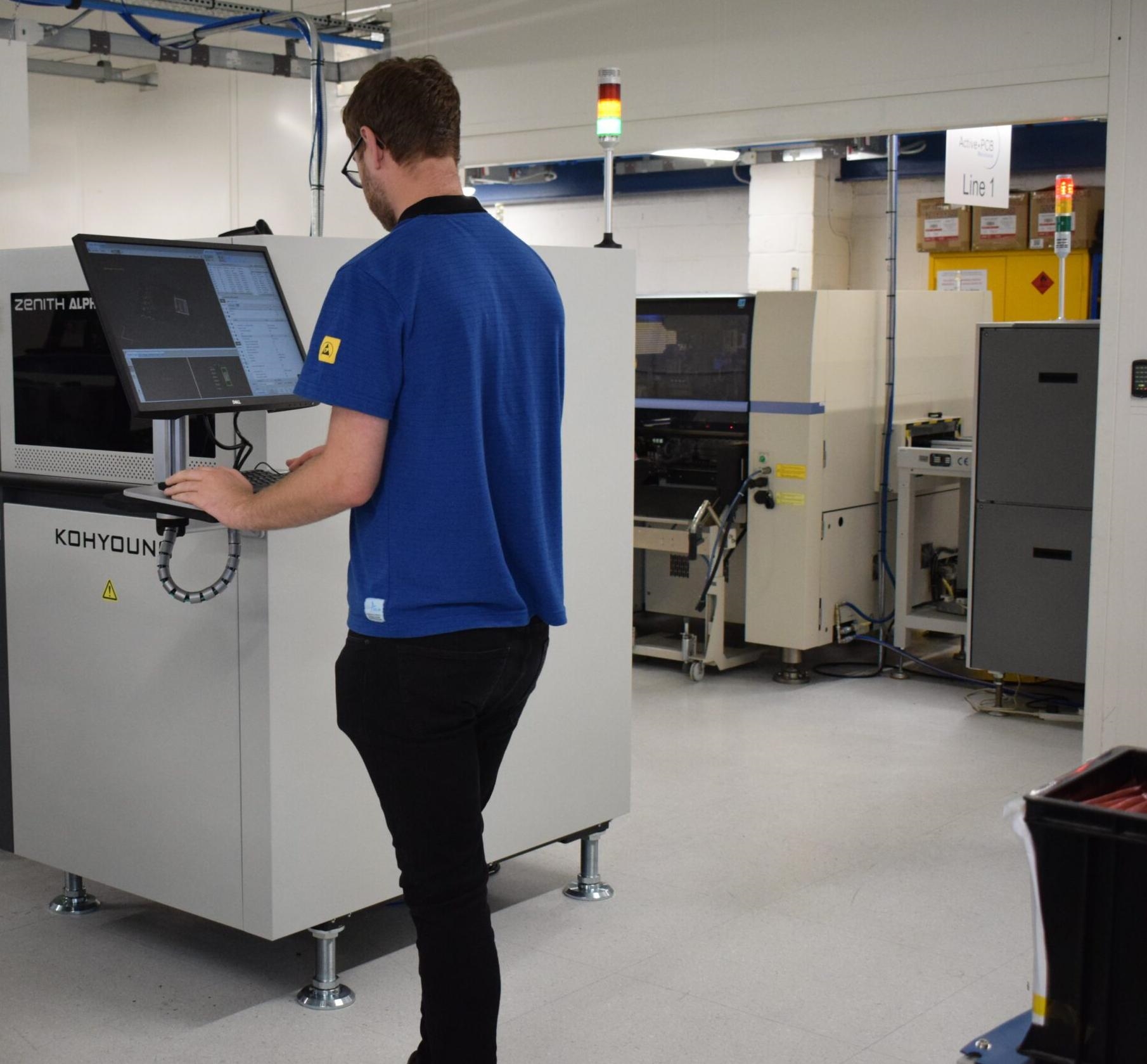 Technician adjusting settings on an AOI system for PCB inspection
