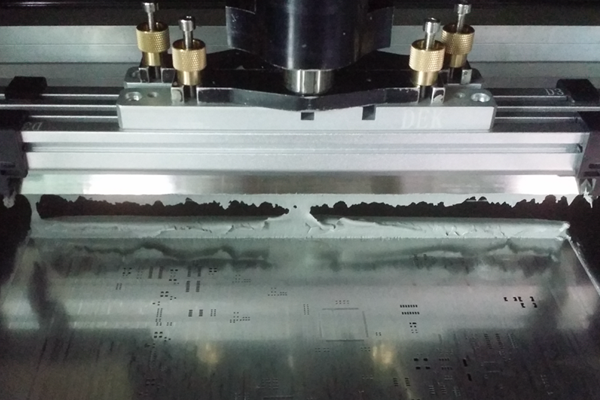 Solder paste application using step-down stencil in PCB assembly process.