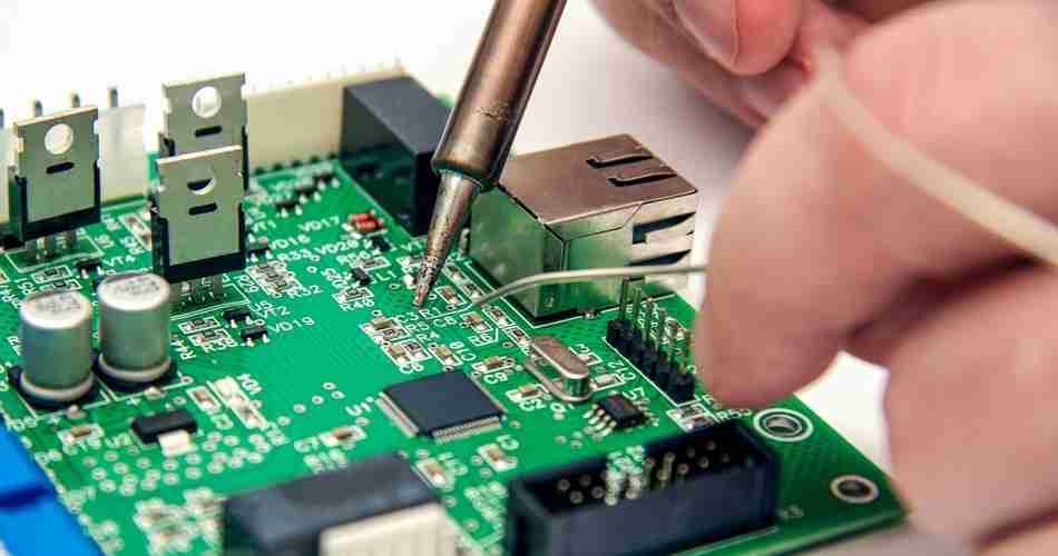 Engineer placing components on a PCB with precision tools
