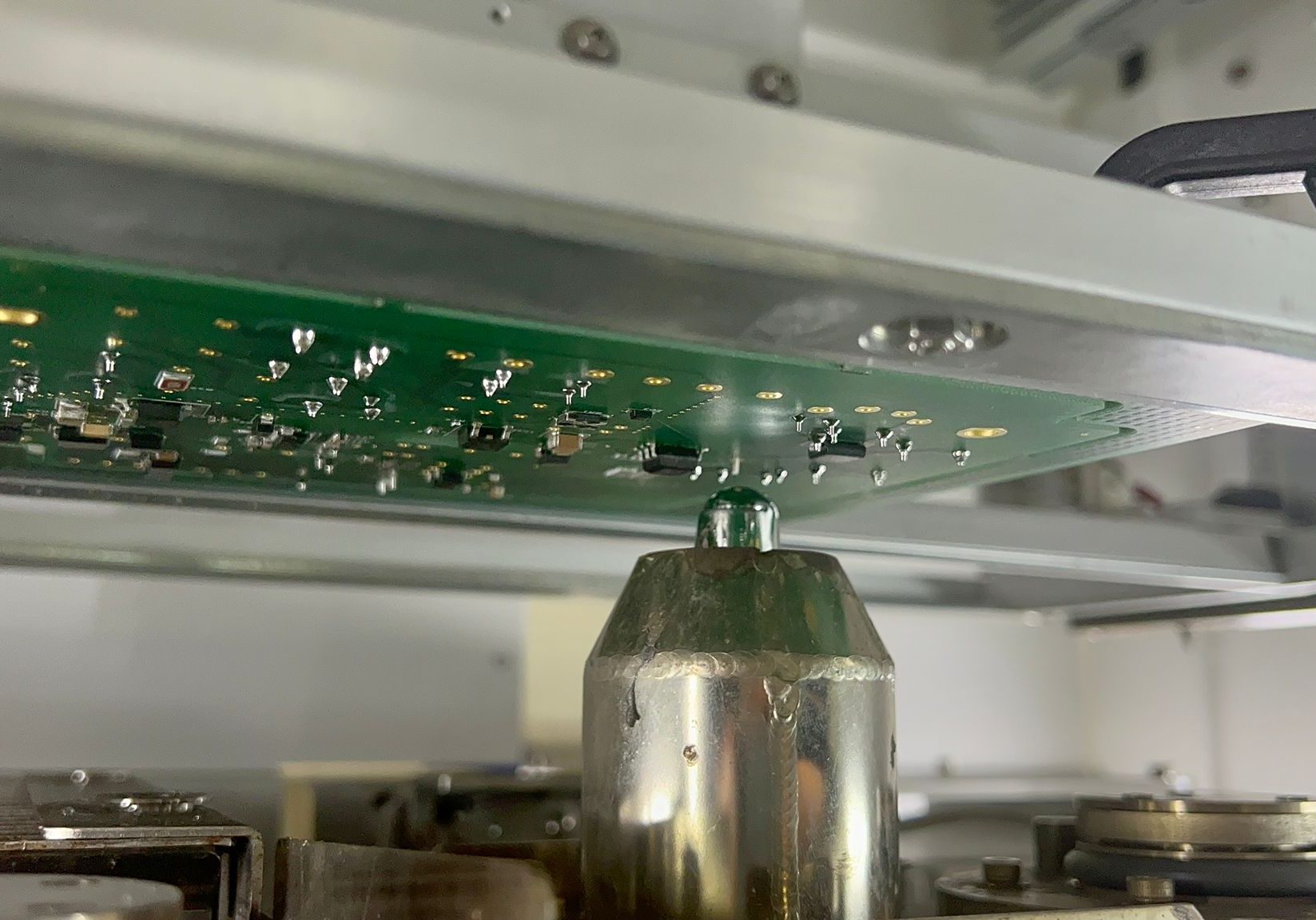 Close-up of solder nozzle under nitrogen purge hood during selective soldering