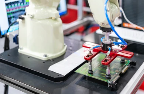 Robotic arm using suction cups to handle a fragile PCB during assembly