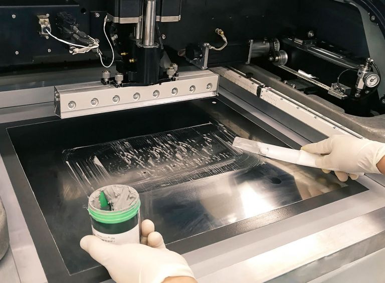 Applying solder paste through a custom stencil on a PCB