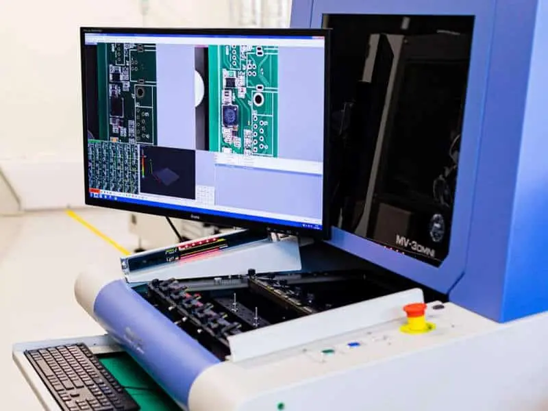 AOI-machine-inspecting-PCB-with-detailed-view-on-monitor