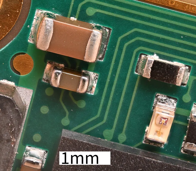Close-up of a PCB via showing the hole ring, pad edge, and adjacent copper