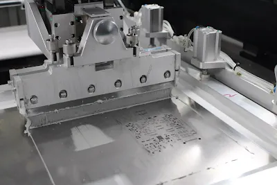 Solder paste being applied to a PCB using a stencil and squeegee