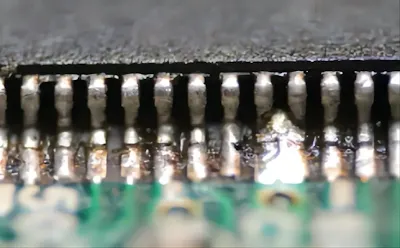 Microscopic view of solder bridging between two PCB pads