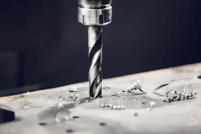 Close-up photograph of a CNC drill bit showing wear on cutting edges next to a cross-section of drilled hole with clean walls versus one with rough edges due to worn tool