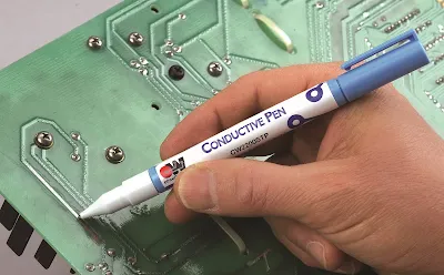 Hobbyist repairing a broken trace on a PCB with a conductive pen