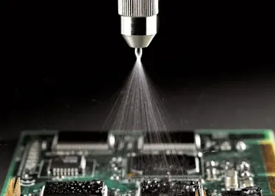 Automated spray nozzle applying conformal coating to a PCB