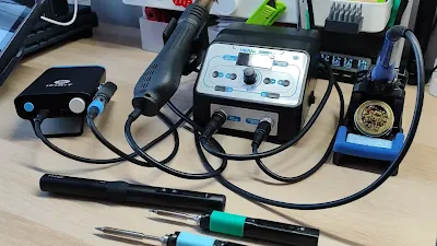 A soldering station with adjustable controls and various tips on a workbench