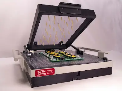 Vacuum cassette fixture (left) and dual-stage pneumatic press (right) on the same Keysight i3070 platform