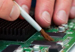 Cleaning PCB pads with a brush and solvent