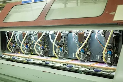 Close-up of a CNC drilling machine creating vias on a PCB