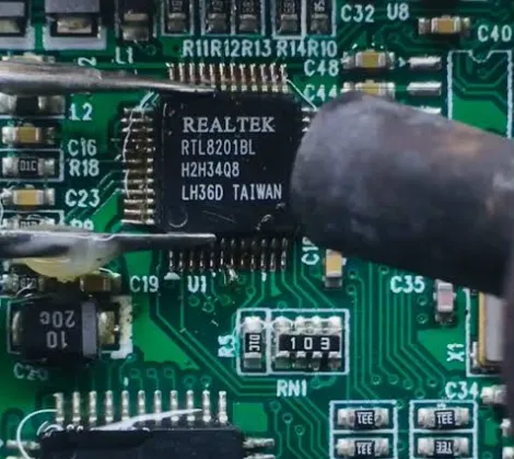 Hot air nozzle positioned 1 cm above QFP chip for controlled solder reflow during safe PCB removal